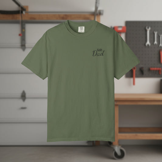 Green t-shirt with 'Girl Dad' text in a workshop setting