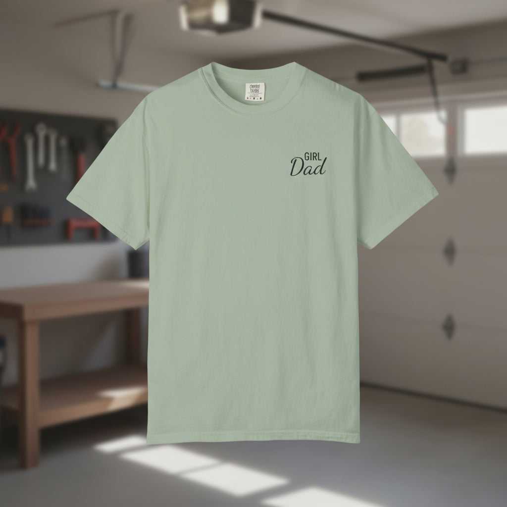 Light green t-shirt with 'Girl Dad' text on a blurred indoor background