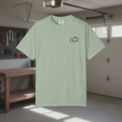 Light green t-shirt with 'Girl Dad' text on a blurred indoor background