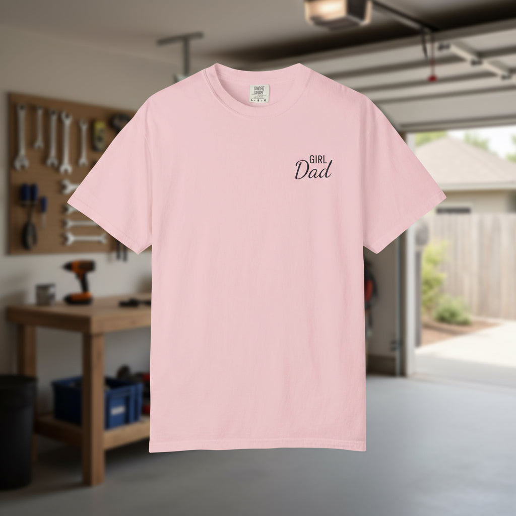 Pink t-shirt with 'Girl Dad' text in a garage setting