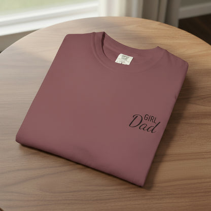 Folded maroon t-shirt with 'Girl Dad' text on a white background