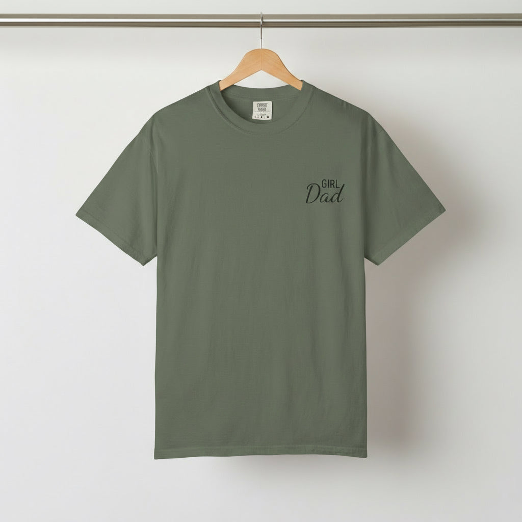 Green t-shirt with 'Girl Dad' text on a hanger against a white background