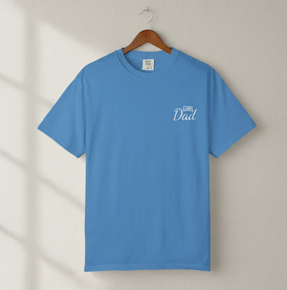Blue t-shirt with 'Girl Dad' text on a hanger against a neutral background
