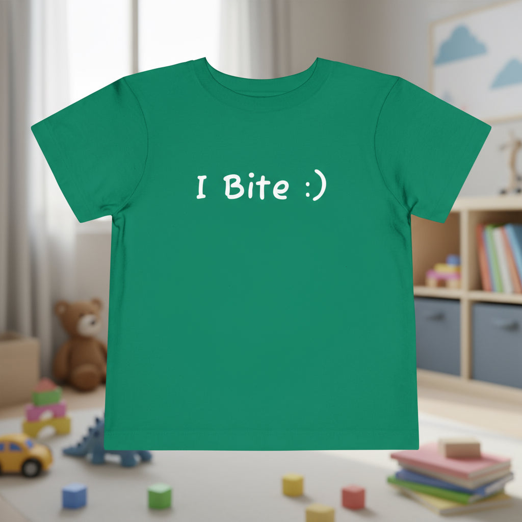 Green t-shirt with 'I Bite :)' text in a room with toys and books.